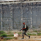 A soldier escorts Wattle through the prison yard.